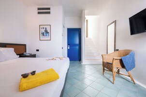 Una camera d'albergo con un letto, una sedia, una televisione e una scala.