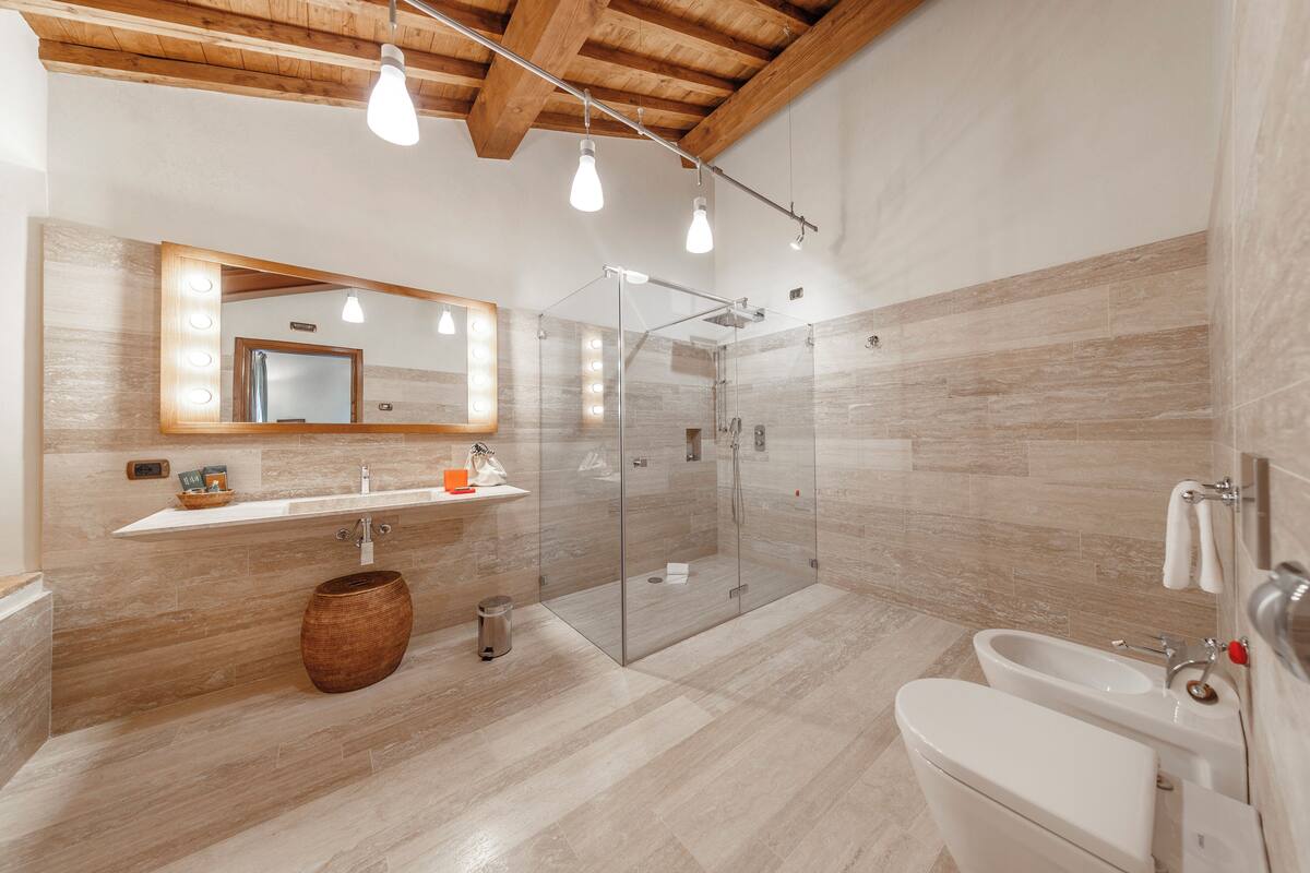 A modern bathroom with a glass-enclosed shower, a vanity with a mirror, and a bathtub.