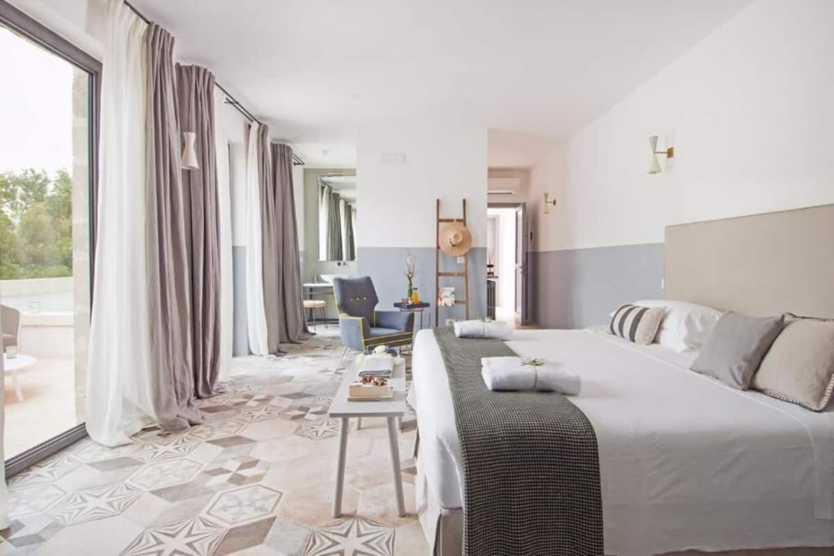 Habitación de hotel con cama, una silla, una mesa y vistas al exterior.