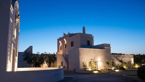 A building with a round courtyard, a central fountain, and a large tree. - Masseria San Giovanni (Fasano)