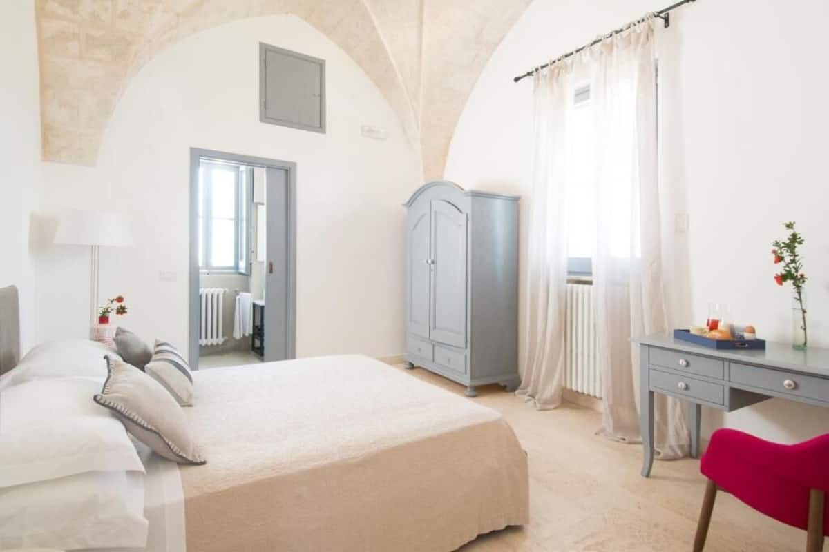 Une chambre à coucher avec un lit, un bureau, une armoire et un radiateur.