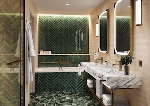 Une salle de bain moderne avec un mur vert orné d’un motif en chevrons, une douche en verre, un meuble-lavabo en marbre et un grand miroir.