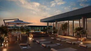 A rooftop terrace with outdoor seating, yoga mats, and potted plants. - Hyatt Regency Rome Central (Rome)