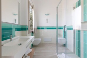 A modern bathroom with a glass shower enclosure, a white sink, and a toilet. - Eliantos Hotel and Spa (Pula)