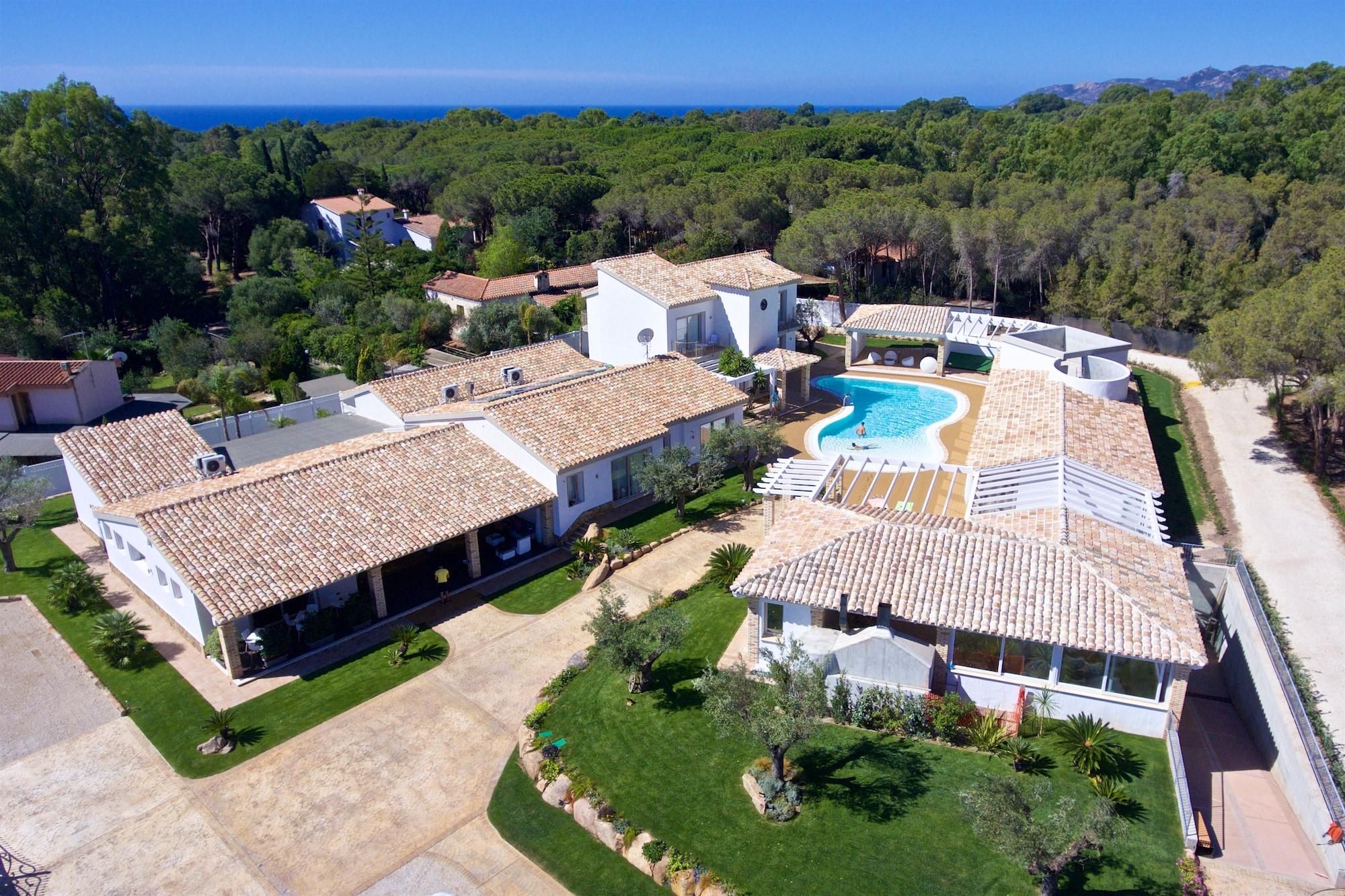 Zona residencial con piscina, casas escalonadas y vista al mar.