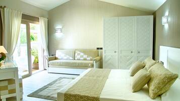 A bedroom with a bed, a sofa, a wardrobe, and a desk with a lamp.