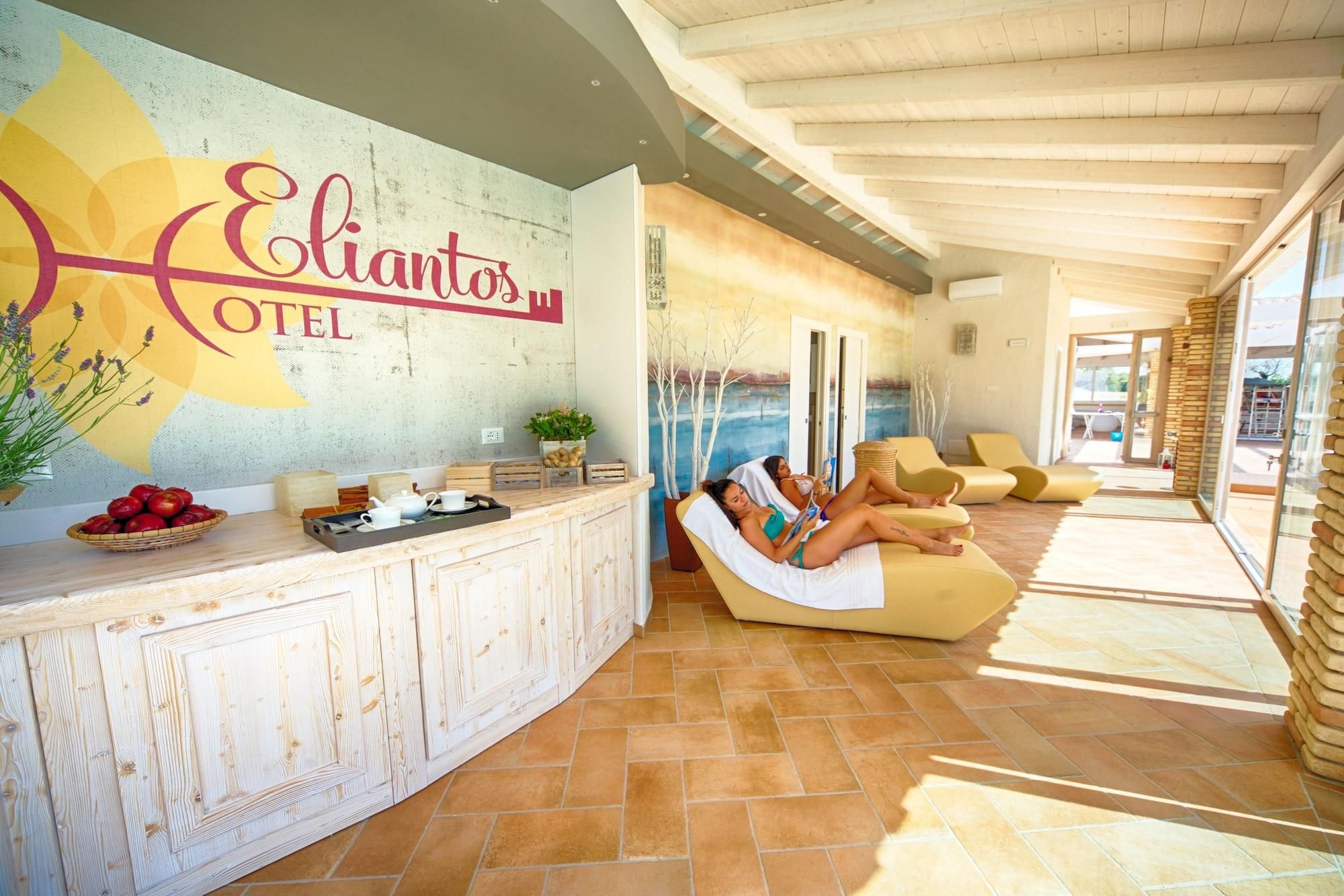 Un lobby moderno de hotel con una recepción, un área de piscina con tumbonas y un amplio ventanal con vistas a la piscina.