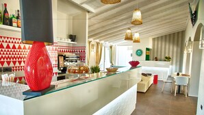 A modern kitchen with a glass counter, a coffee machine, and a red decorative item. - Eliantos Hotel and Spa (Pula)