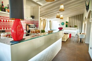 A modern kitchen with a glass counter, a coffee machine, and a red decorative item. - Eliantos Hotel and Spa (Pula)