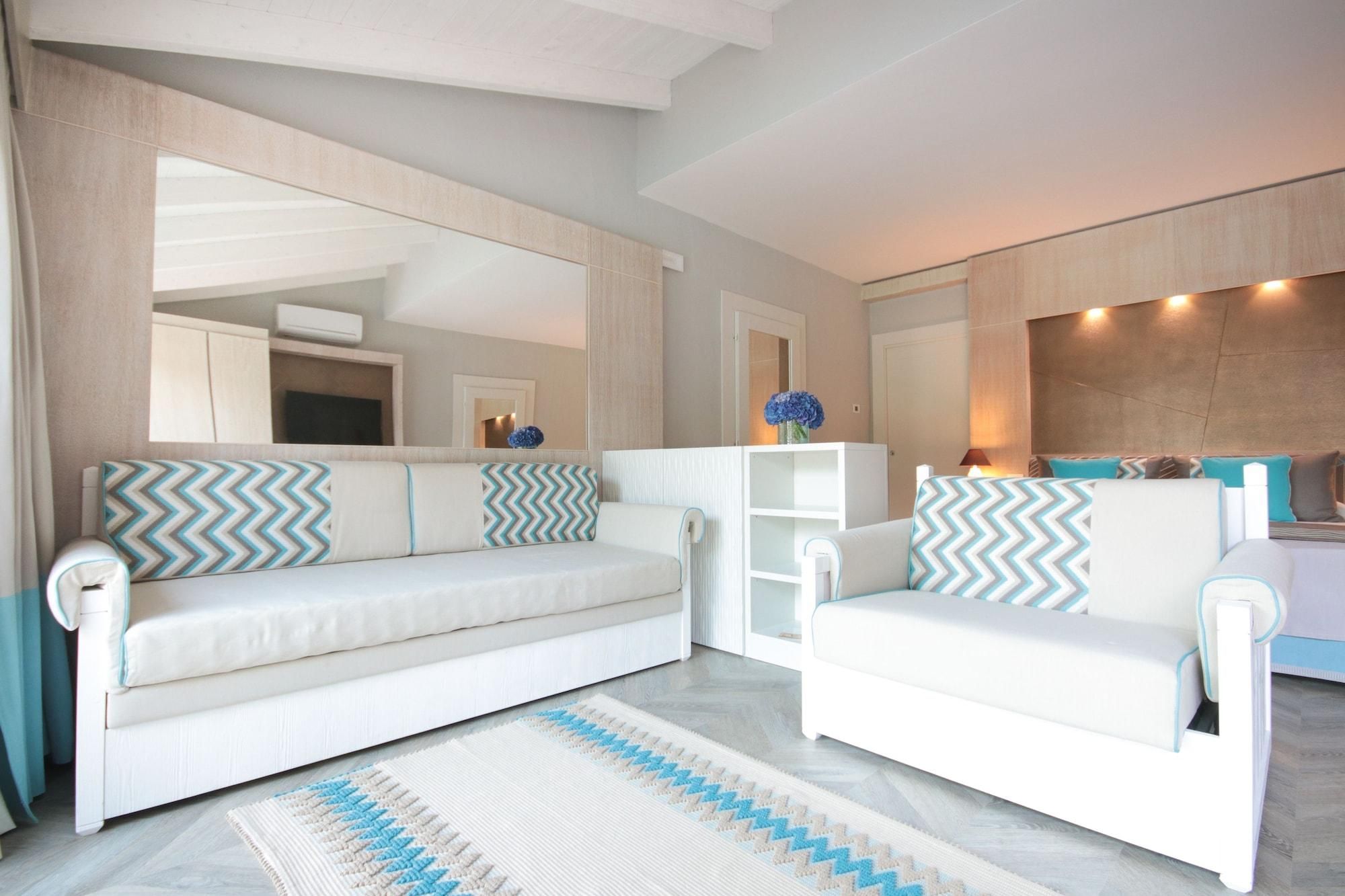 Una sala de estar moderna con un sofá blanco, un tapete estampado y un espejo grande.