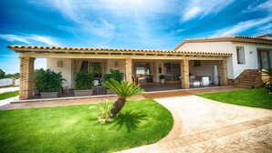 A modern house with a covered patio, a well-maintained lawn, and a stone pathway leading to the entrance. - Eliantos Hotel and Spa (Pula)