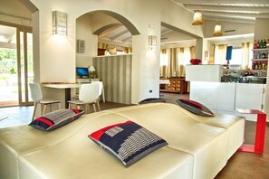 A modern living room with a sofa set, a dining area, and a kitchen. - Eliantos Hotel and Spa (Pula)