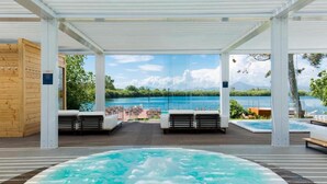 Un espace avec un bain à remous offrant une vue sur un lac et des montagnes.