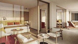 Een moderne hotelkamer met een groot bed, een slaapbank, een eettafel en een zithoek met een stoel.