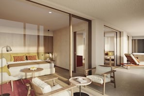 Een moderne hotelkamer met een groot bed, een slaapbank, een eettafel en een zithoek met een stoel.