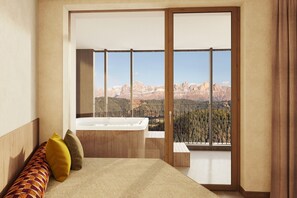 A bedroom with a large sliding glass door leading to a balcony, a wooden bed, and a bathtub.