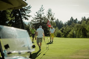 A golf course with players and a golf cart. - Ganischgerhof - Mountain Resort & Spa (Nova Ponente)