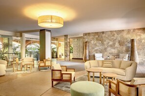 A spacious lobby with a stone wall, comfortable seating, and a large chandelier. - Veridia Resort, a Member of Radisson Individuals (Domus de Maria)