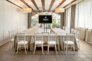 A conference room with a long table, white chairs, a large screen displaying 'VERIDIA the nature resort of Cila', and a view of greenery outside. - Veridia Resort, a Member of Radisson Individuals (Domus de Maria)
