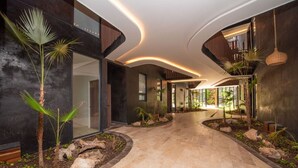 Een modern interieur met vloeiende wanden, een centrale doorgang en tropische planten.