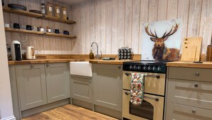A kitchen with wooden cabinets, a stove, and a sink.