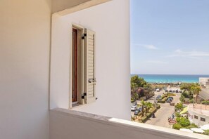 Ein Balkon mit Meerblick und einem Parkplatz.