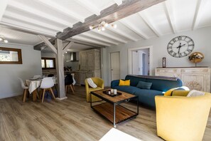 En stue med sofa, stole, et sofabord og et spiseområde med bord og stole.