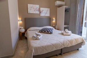 A bedroom with a large bed, two wall-mounted artworks, a bedside table with a lamp, and a wardrobe. - P.c. Boutique H. Sea View (Naples)