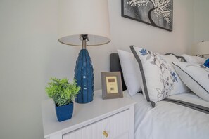 A neatly arranged bedroom with a bedside table, a lamp, a framed picture, and a potted plant. - Escape the Winter! Cozy 3BR Retreat in Sunny Ocala, Florida (Ocala)