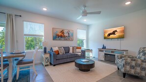 A living room with a sofa, coffee table, TV, and artwork on the walls. - Escape the Winter! Cozy 3BR Retreat in Sunny Ocala, Florida (Ocala)