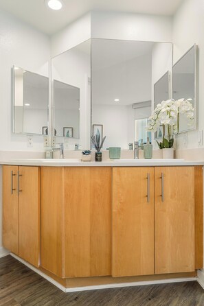 A modern bathroom with a large mirror, wooden cabinets, and a white countertop. - The Navagio' Waterfront Penthouse 3 Levels, Private Rooftop Boats View Parking (Marina del Rey)