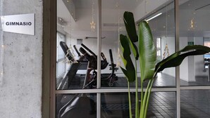 Een sportschool met loopbanden en hometrainers, een bord waarop 