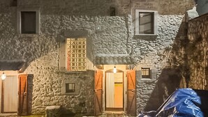 A stone building with multiple windows and doors, some with curtains. - 4 bedroom cozy home in Montenero Val Cocchiar (Montenero Val Cocchiar)