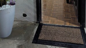 Un pasillo que da a una cocina con un refrigerador blanco, un fregadero y un armario de madera oscura.