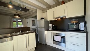 A modern kitchen with white cabinets, a stainless steel refrigerator, a built-in oven, and a microwave. - MENDIA - SAINT PIERRE D'IRUBE (SAINT-PIERRE-D'IRUBE)