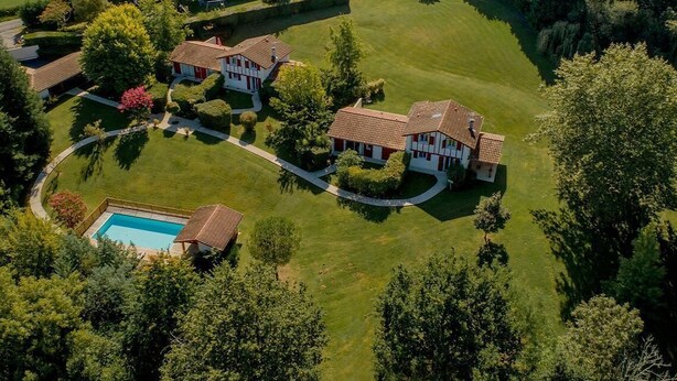 An aerial view of a residential property with a swimming pool, multiple houses, and well-maintained lawns. - MENDIA - SAINT PIERRE D'IRUBE (SAINT-PIERRE-D'IRUBE)