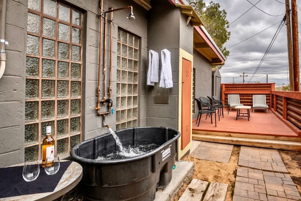 A spa area with a hot tub, a window with frosted glass, and outdoor seating.