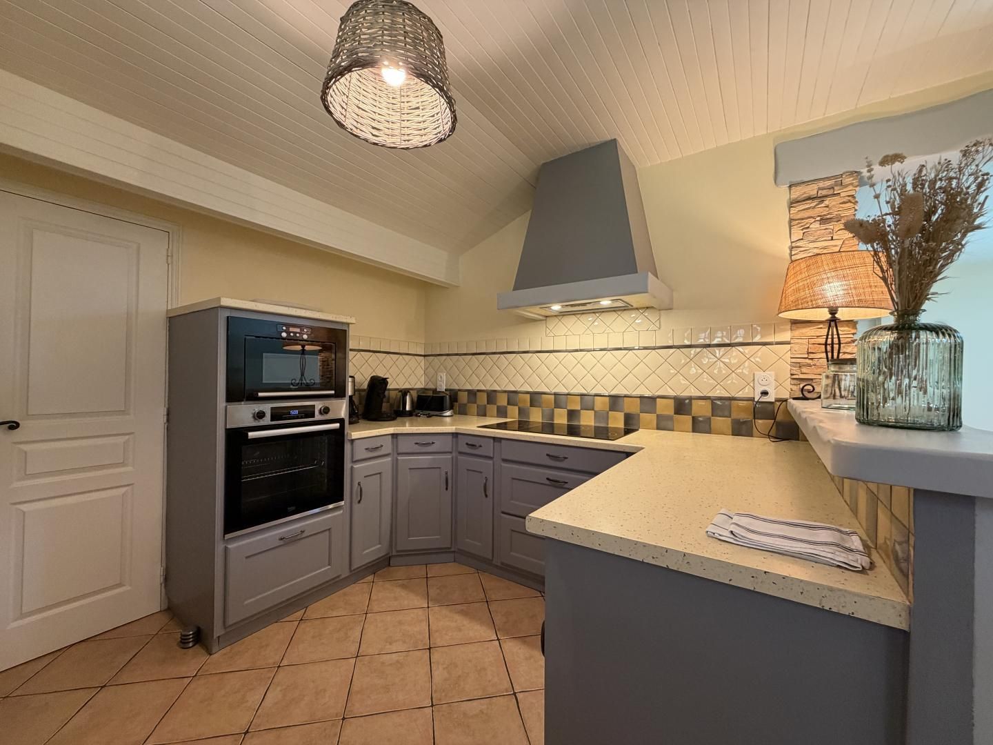 Una cucina con forno a incasso, piano cottura, lavello e un ripiano.