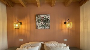 Un dormitorio con una cama, dos mesitas de noche y dos lámparas de pared.