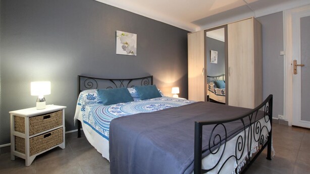 A bedroom with a bed, bedside tables, a wardrobe, and a mirror. - PIERRE BAITA - GUETHARY (GUETHARY)