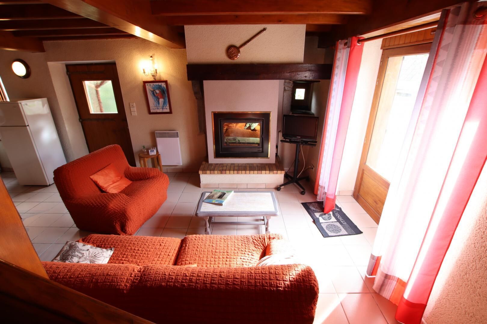 Una sala de estar acogedora con chimenea, un sofá, una mesa de centro y un televisor.