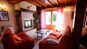 A cozy living room with a fireplace, comfortable seating, and a television. - SALATUA - MUSCULDY - Gîte (MUSCULDY)