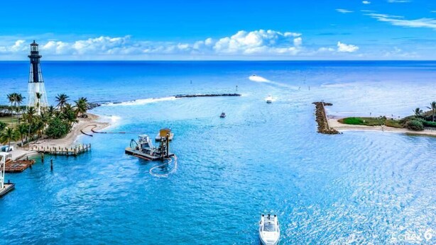 A coastal scene with a lighthouse, boats, and a pier. - Condo With Heated Pool! Beach & Ocean Access! (Pompano Beach)