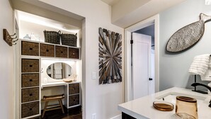 A bathroom with a white vanity, a large mirror, and a decorative wall piece. - Condo With Heated Pool! Beach & Ocean Access! (Pompano Beach)