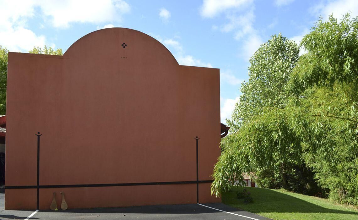 Een gebouw met een gebogen dak en een platte gevel.