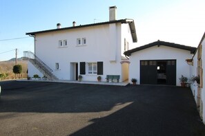 A two-story white building with a staircase, a garage, and a paved driveway. - IRIBURU-BERRIA - SARE (SARE)