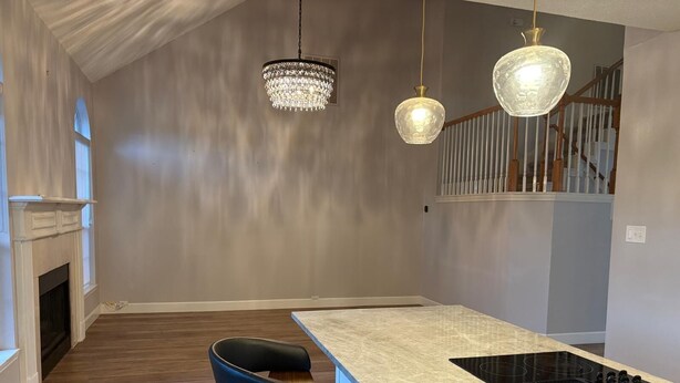 A modern kitchen with a central island, black bar stools, a built-in stove, and a chandelier. - Soothing 4-bedroom house with AC in charming Plano (Plano)