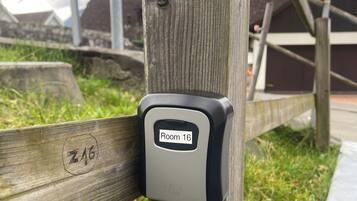 Een houten paal met een bordje met het nummer 'Kamer 16' en het merk 'EASY HOME'.