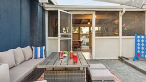 Eine möblierte Terrasse im Freien mit einer Couch, einem Tisch und Stühlen.