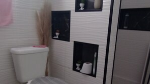 A bathroom with a toilet, bidet, and a shower area. - Ksl bird refuge (Araquari)